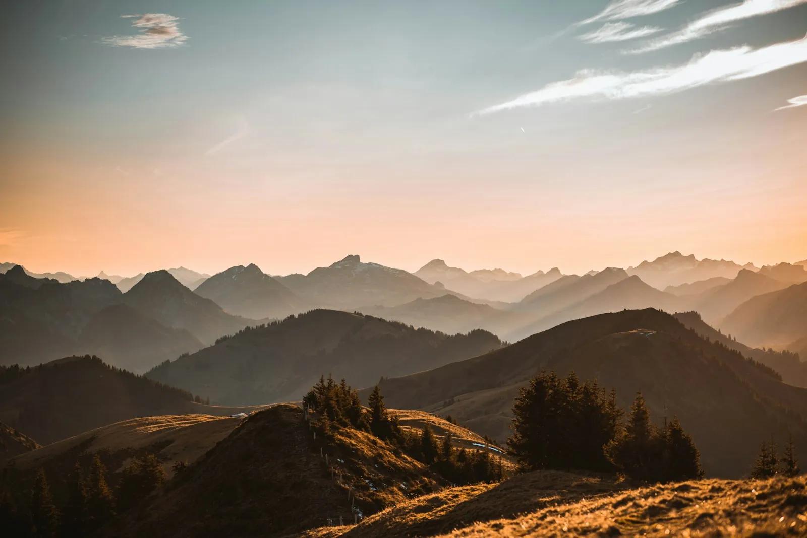 Layered mountain ridges under a warm sky