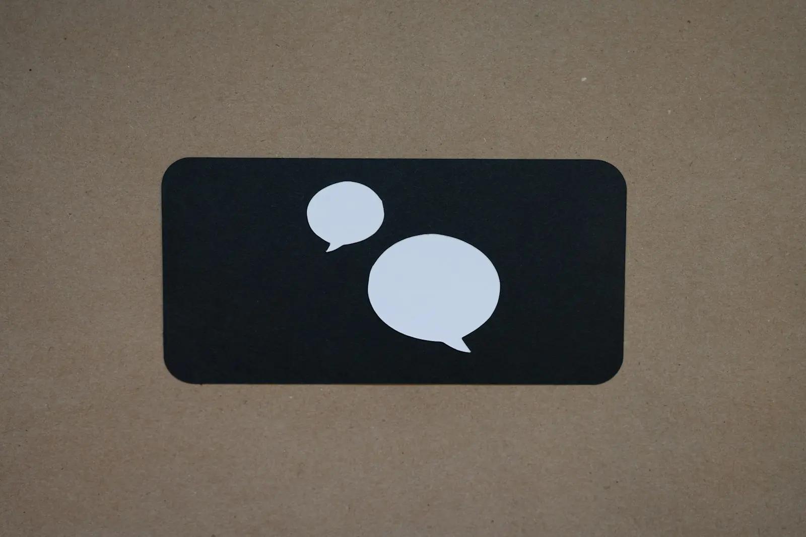 Two white paper speech bubbles on a dark rounded square