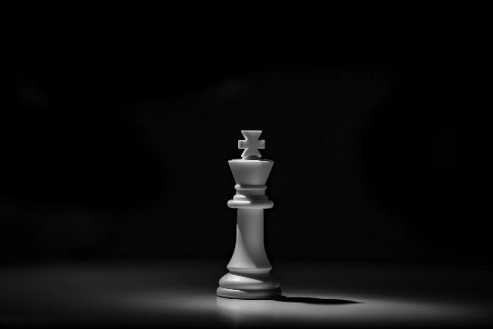 White chess king lit against a dark background
