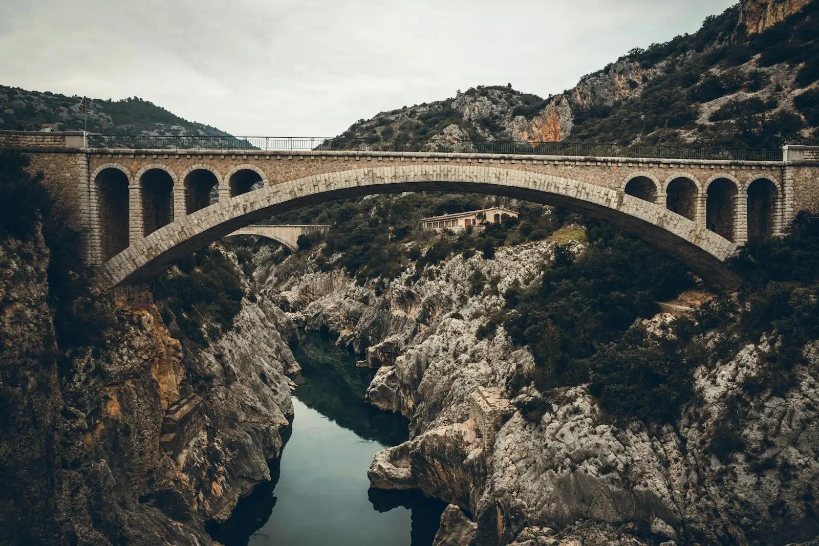 Stone arch bridge spanning a rocky river gorge
