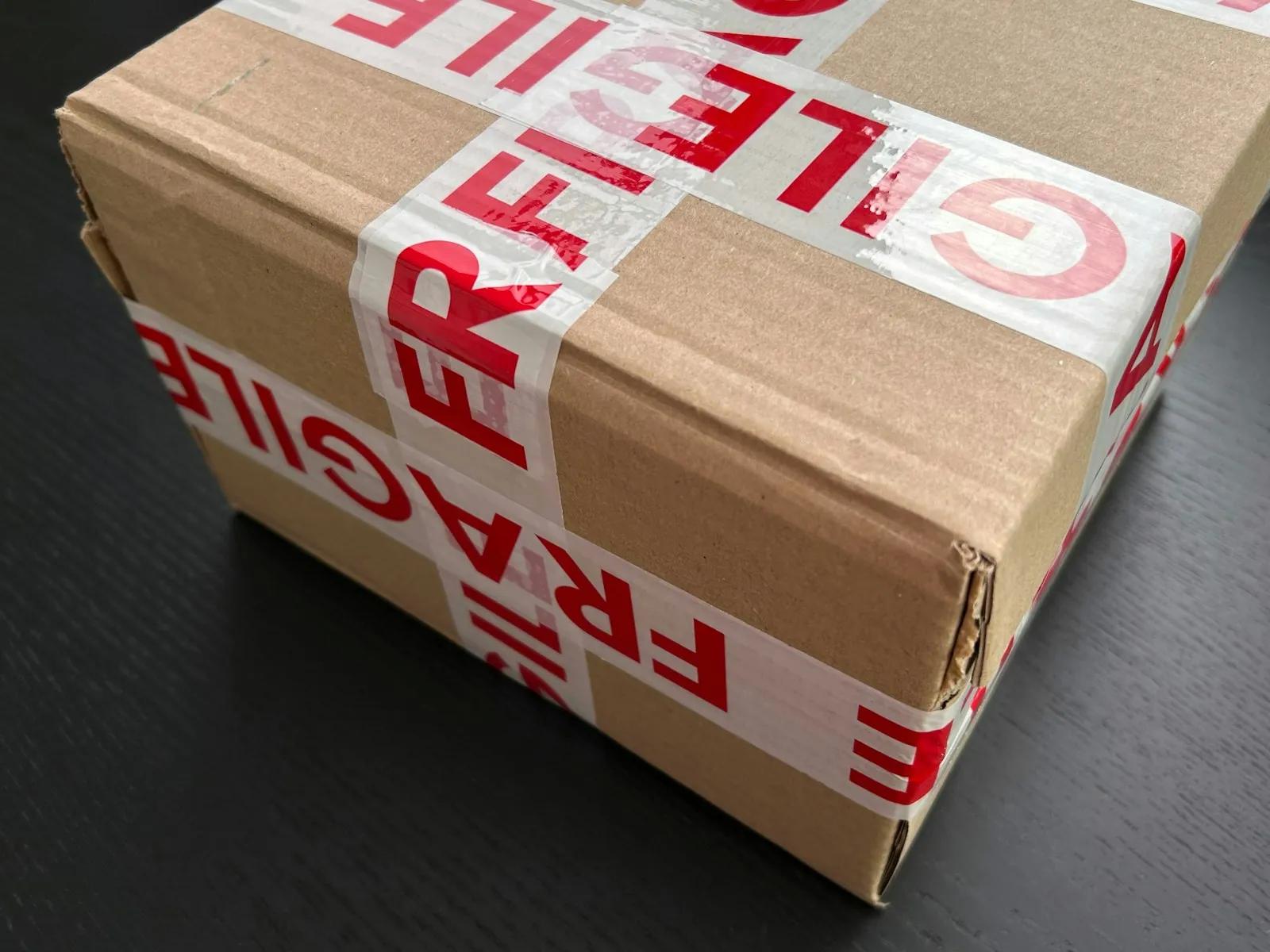A cardboard parcel sealed with fragile tape