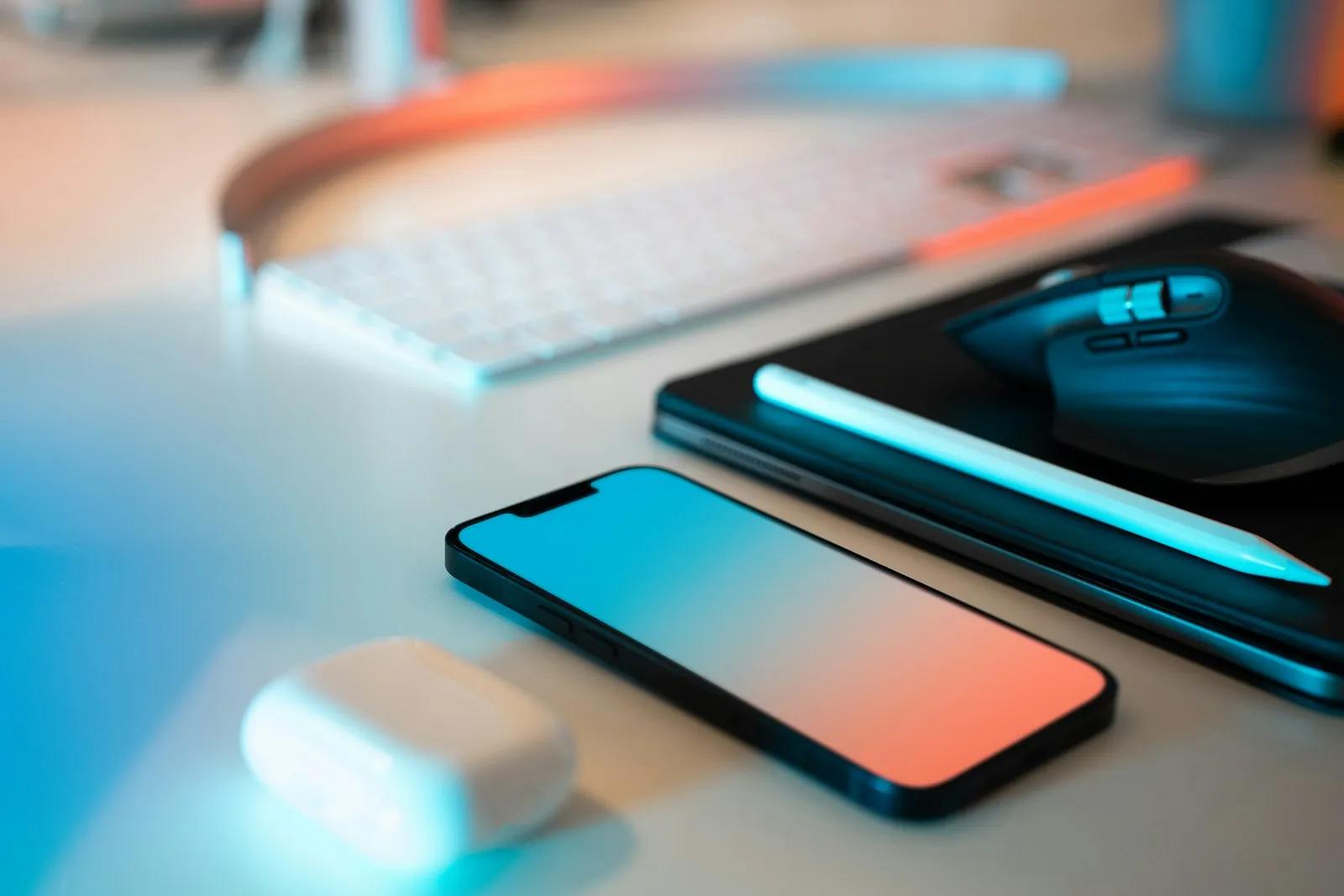 A smartphone, keyboard and mouse on a desk
