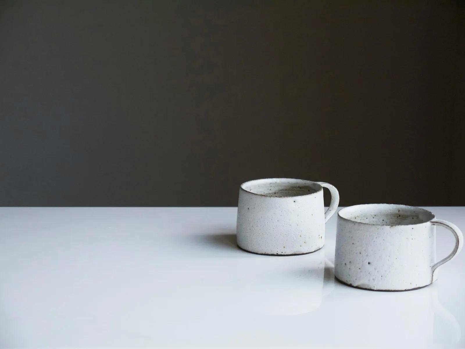 Two white ceramic mugs on a table