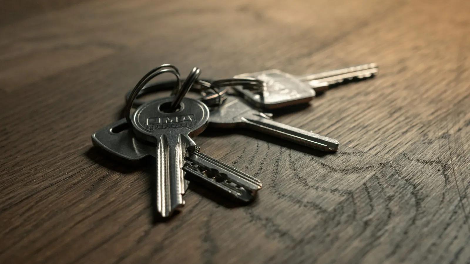 A bunch of metal keys on a wooden table