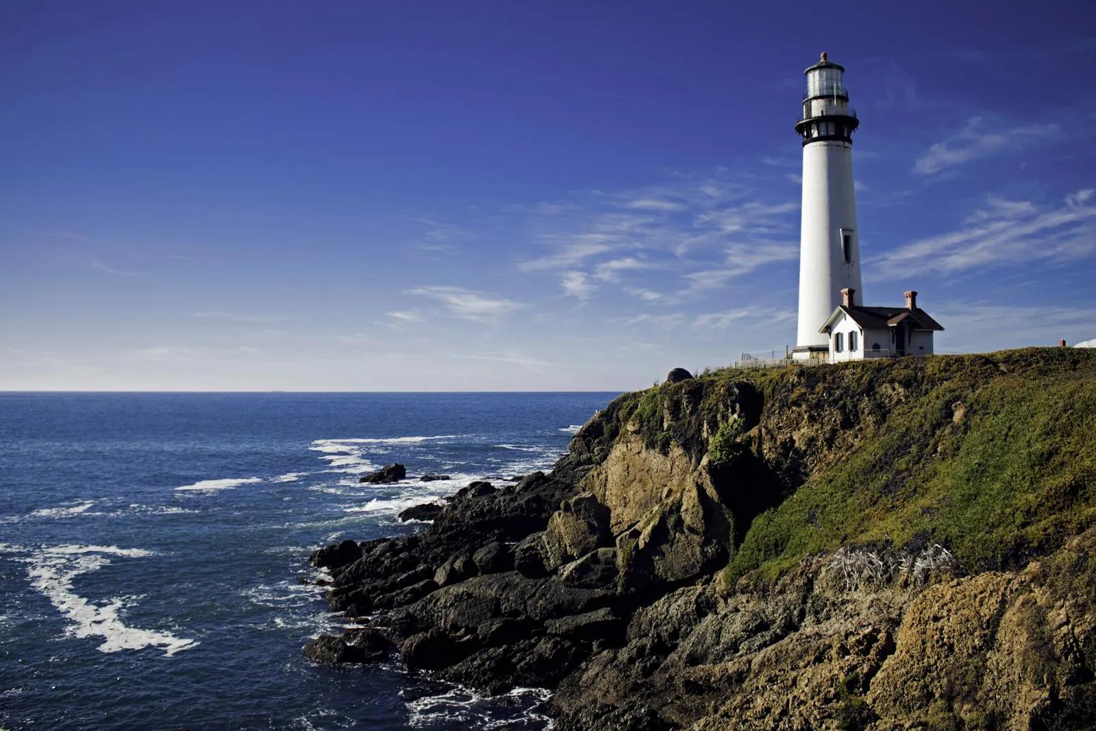 A white lighthouse under a cloudy sky