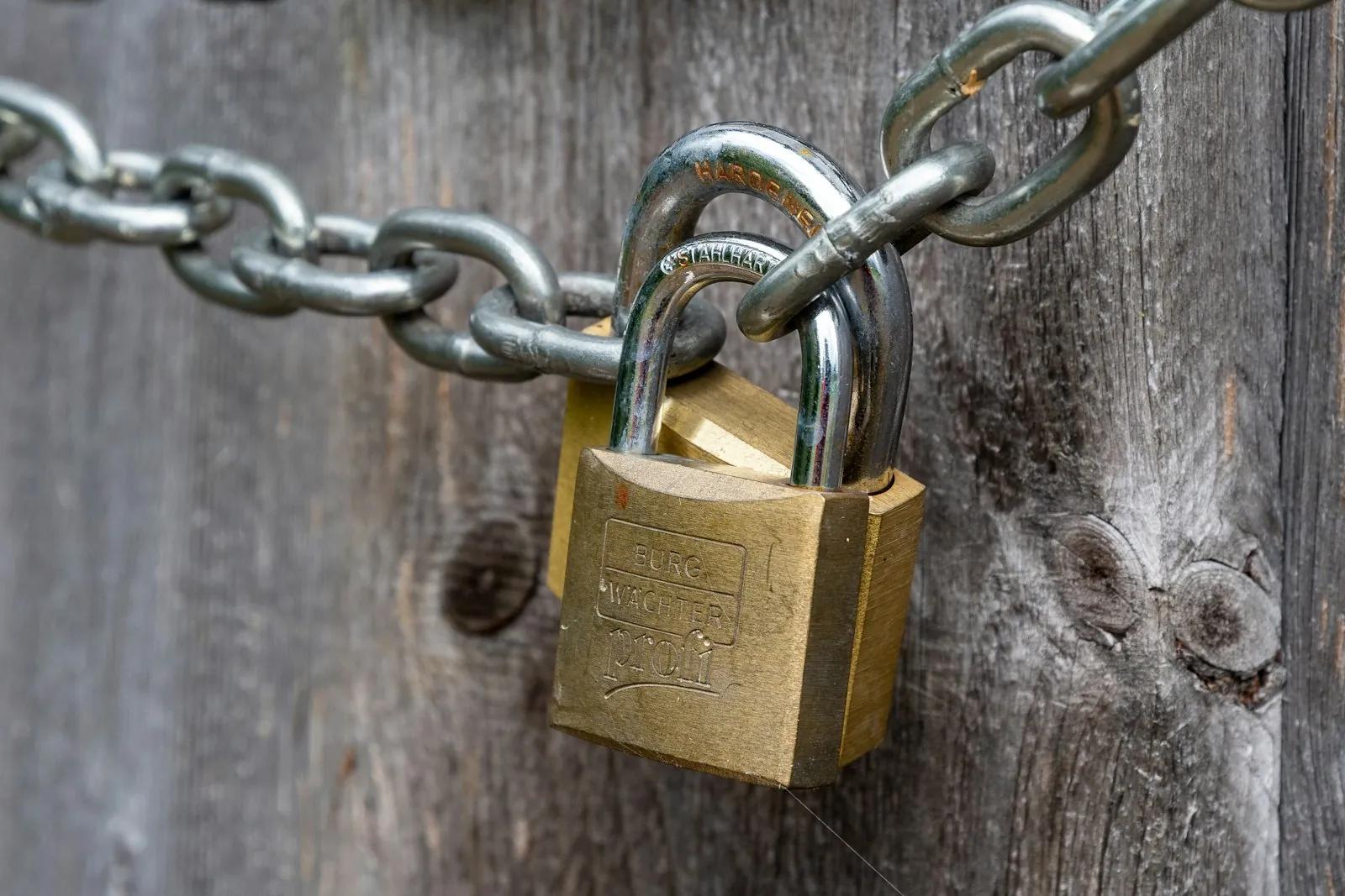An old padlock hanging on a wooden fence