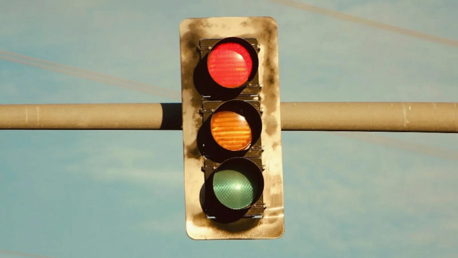 A traffic light hanging from a metal pole