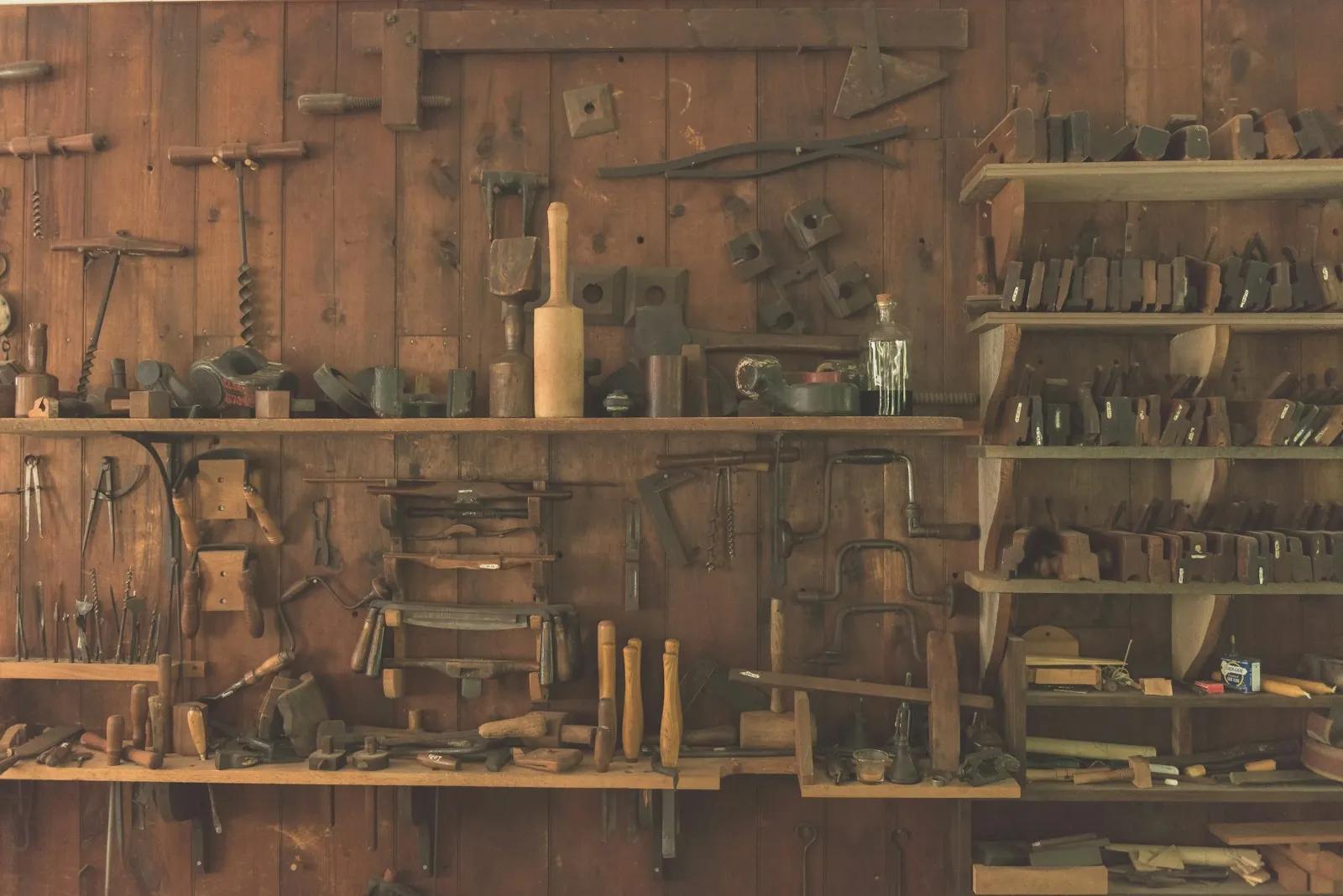 Hand tools arranged on wooden workshop shelves